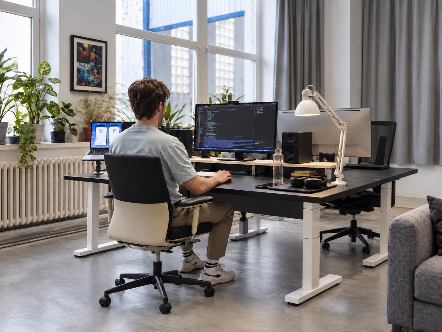 Jakub Smolík při práci u stolu s monitorem a notebookem